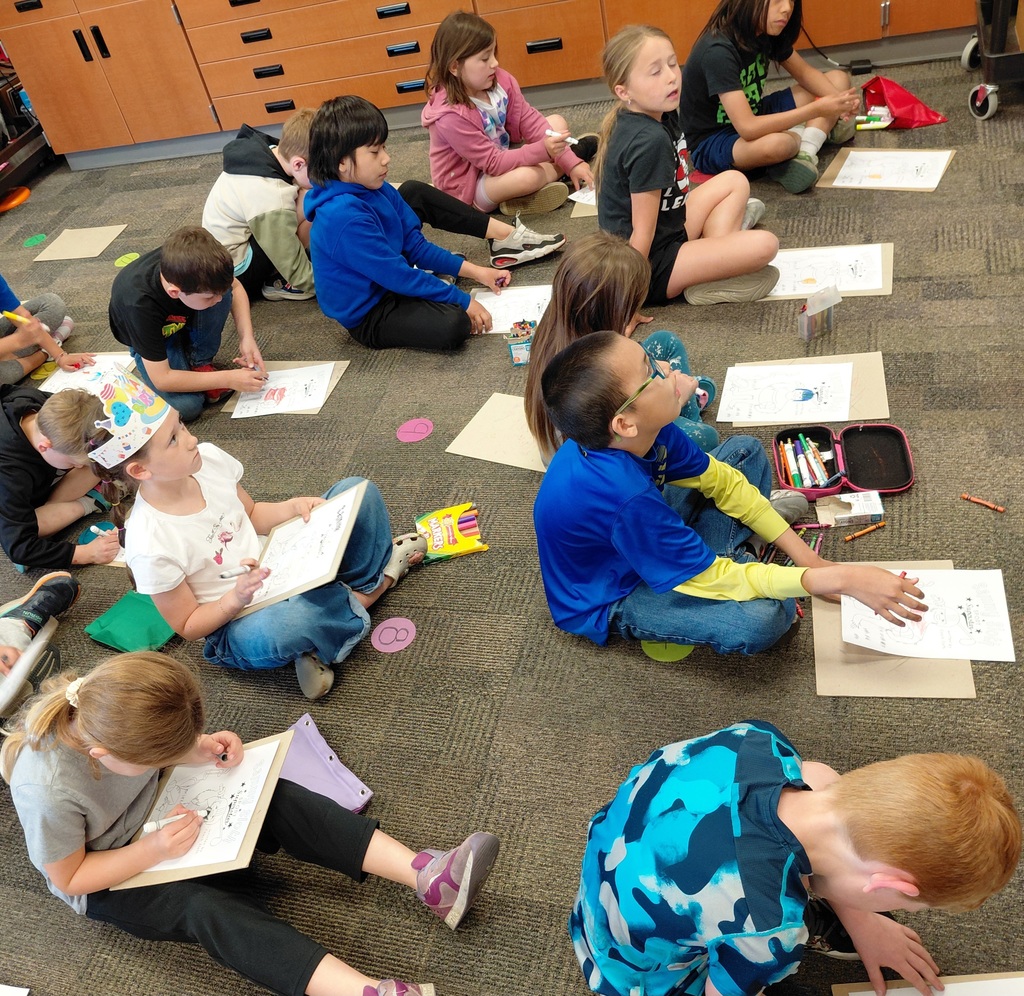 Students drawing while sitting on the floor