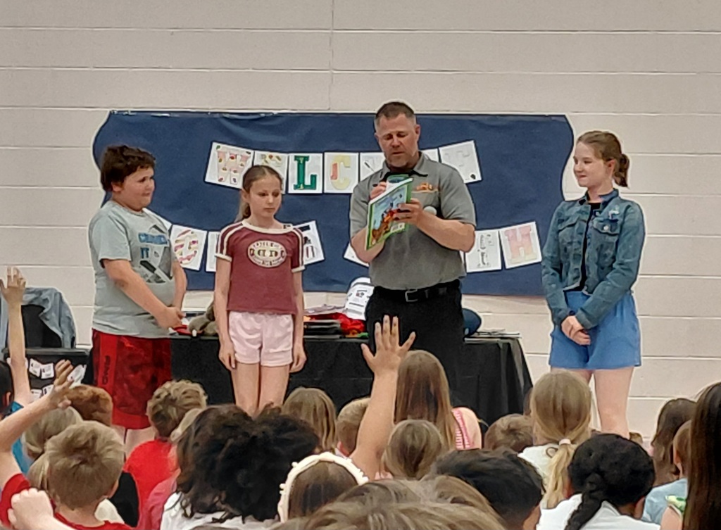Man signing books for 3 students
