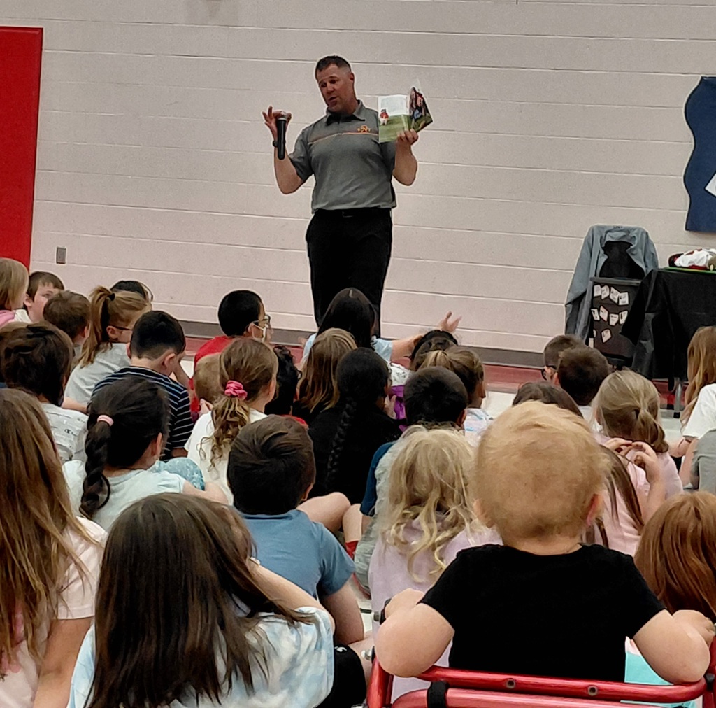 man reading a book to a group of kids