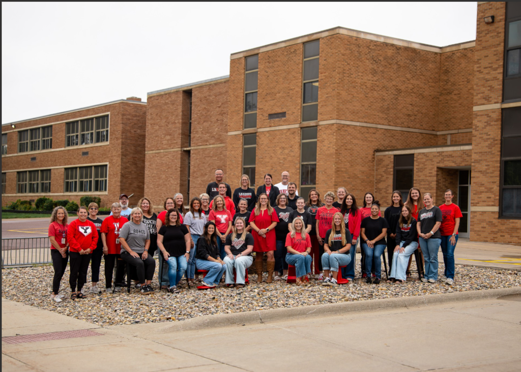 Lincoln Elementary Staff 26-27 A Group of individuals wearing black and red standing in front of Lincoln Elementary Building.