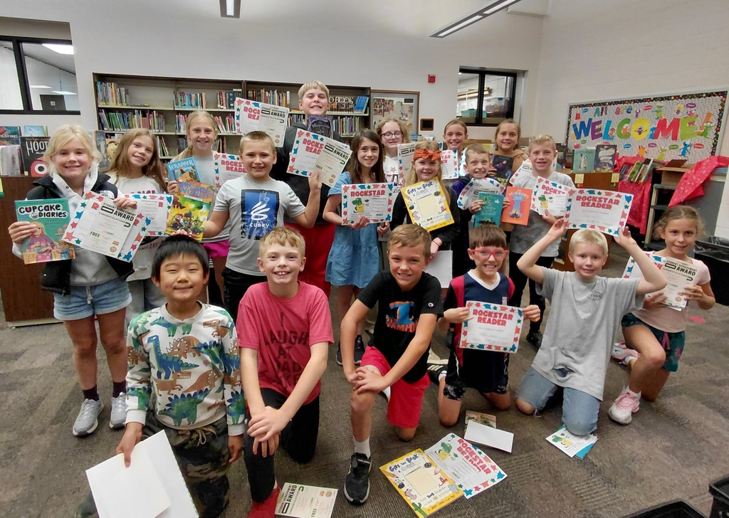 group of students holding papers in library