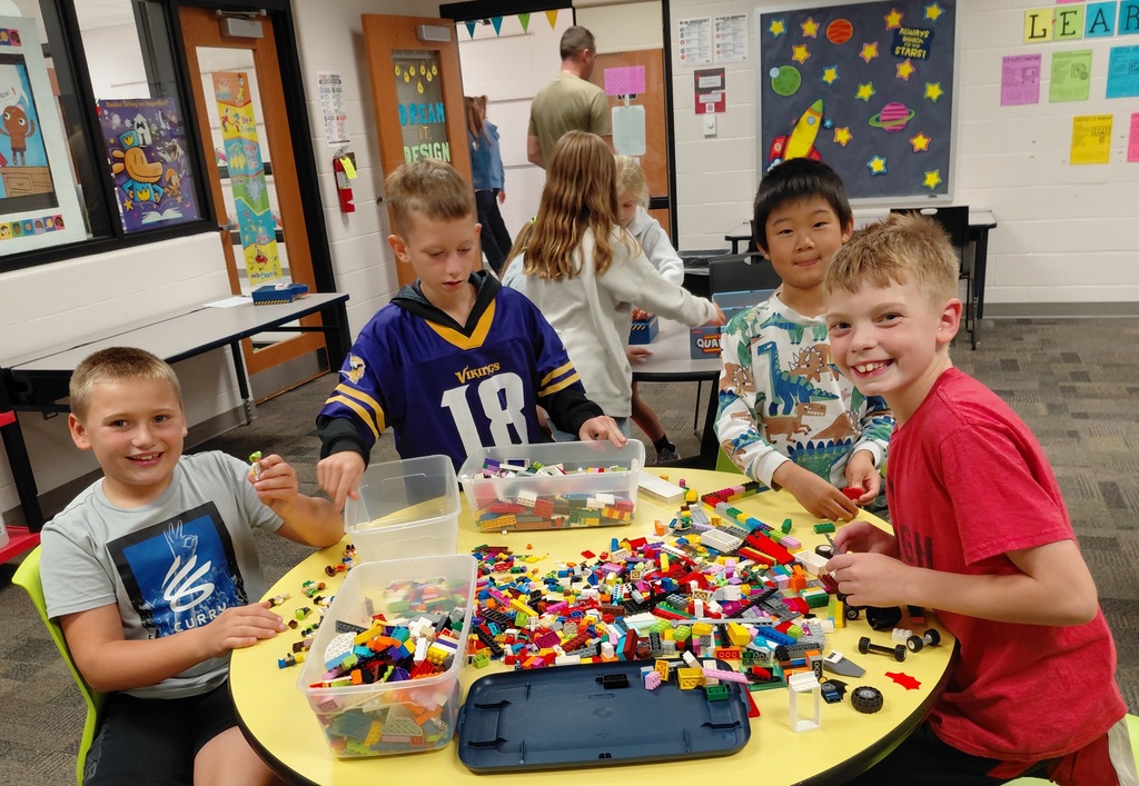 4 boys at a table building with legos