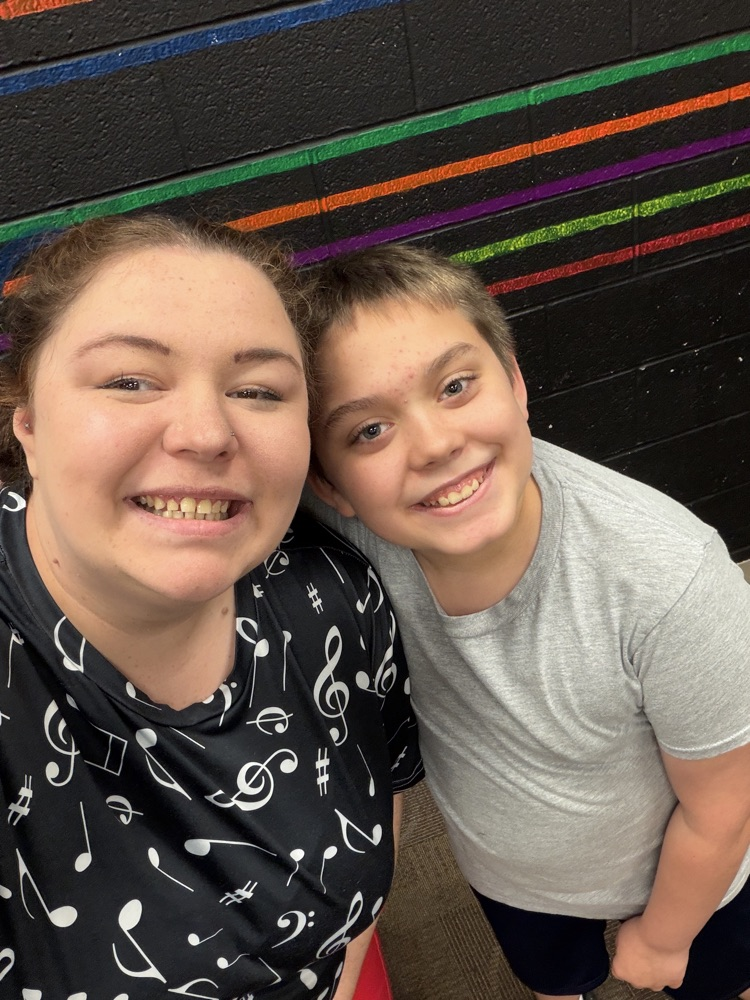 student and teacher smiling at camera