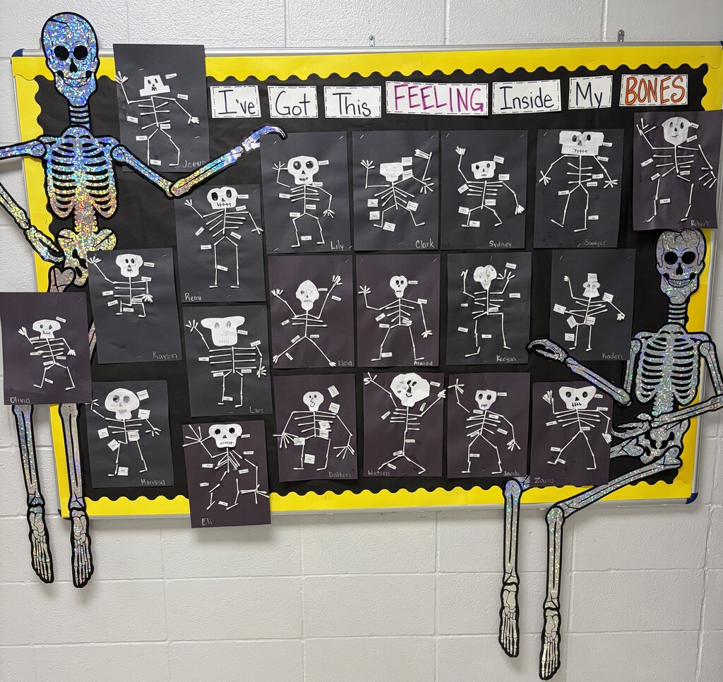 bulletin board with skeletons on black paper