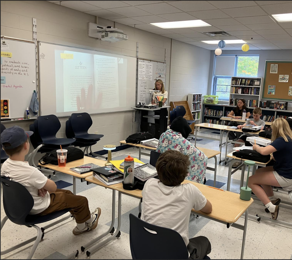 8th grade students listen to a read aloud of our One Book, One School book