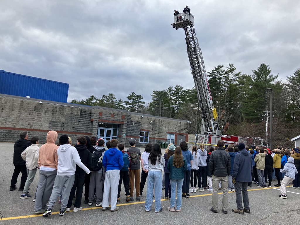 8th Grade students watching their egg drop projects drop from a YFD ladder bucket