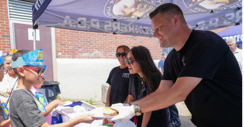 PBA member serves a student a hot off the grill hamburger