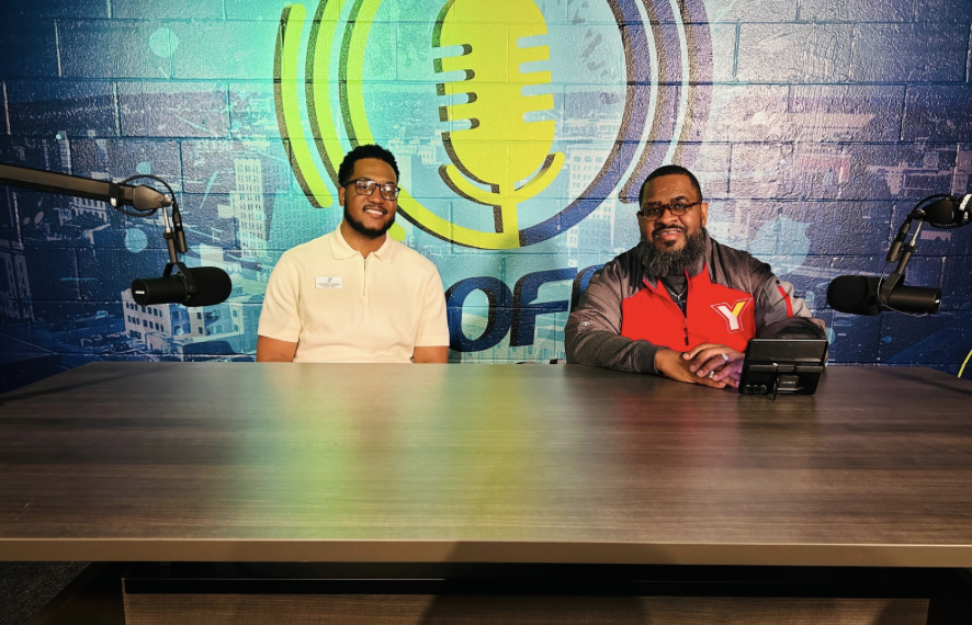 two men sitting behind a desk for interview