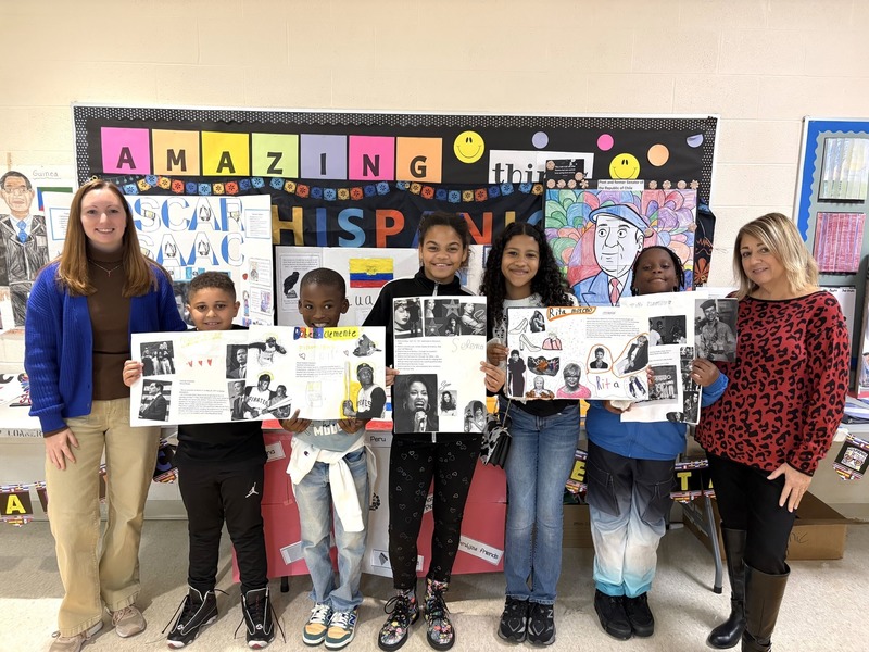 group of students with hispanic heritage month projects on poster boards