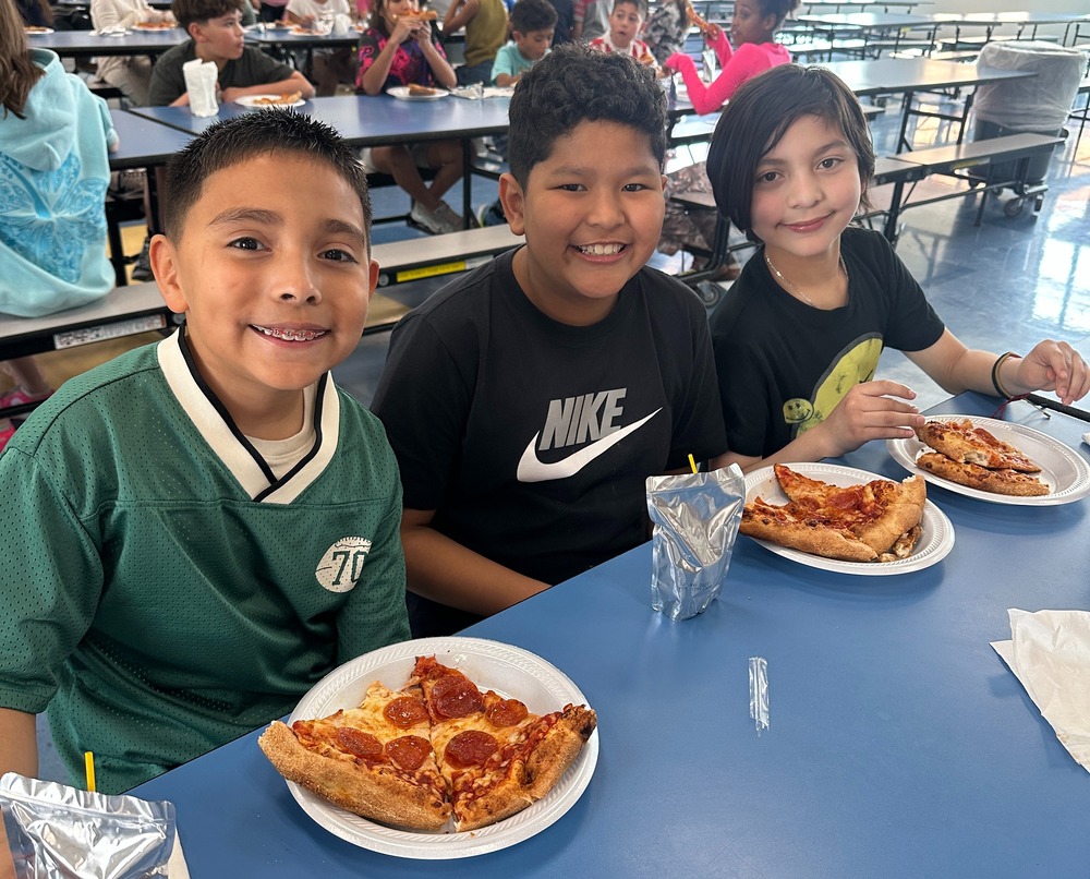 students smiling eating pizza