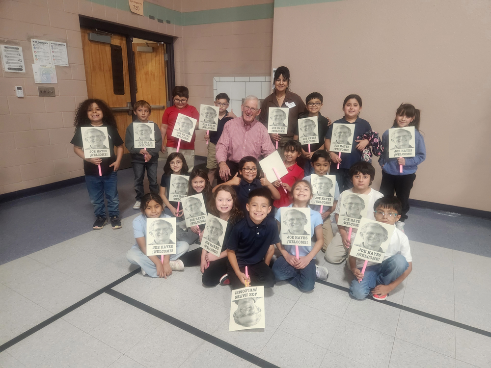 Ms. Aria's Class holding welcome signs for Joe Hayes