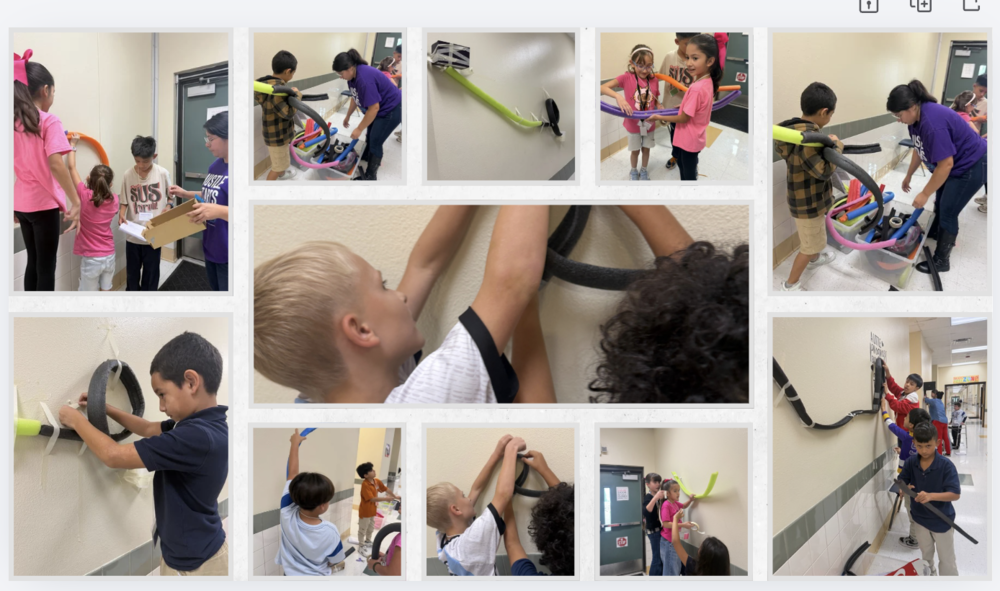 students creating roller coster loops on wall for STEM