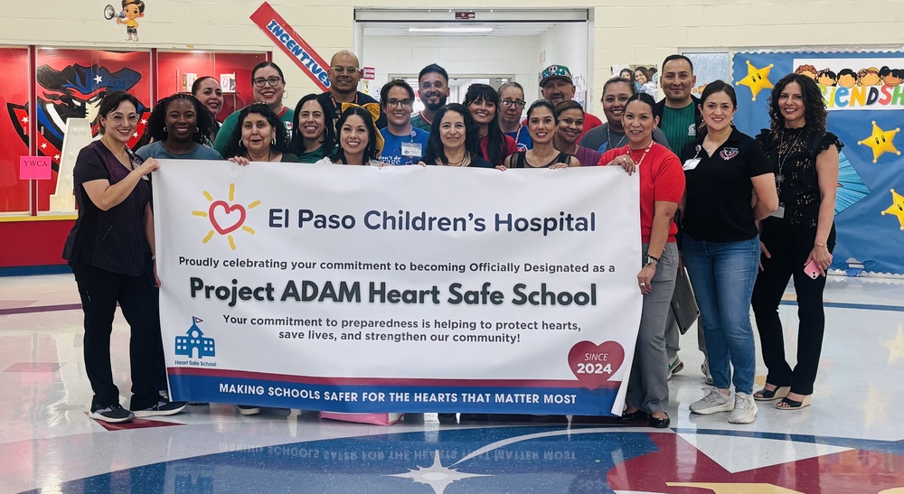 North Star staff hold up banner celebrating the accomplishment of becoming a Project ADAM heart safe school
