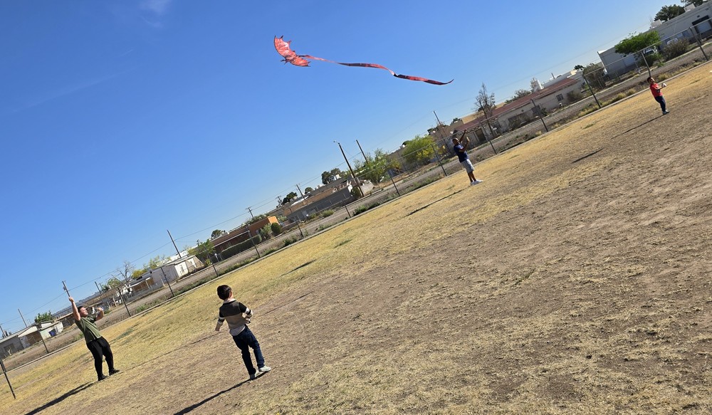 Students and parents flying kites on the Presa field a red dragon kite is being flown