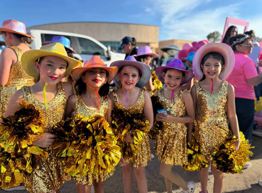 5 evolution dance members pose in their gold glitter costume