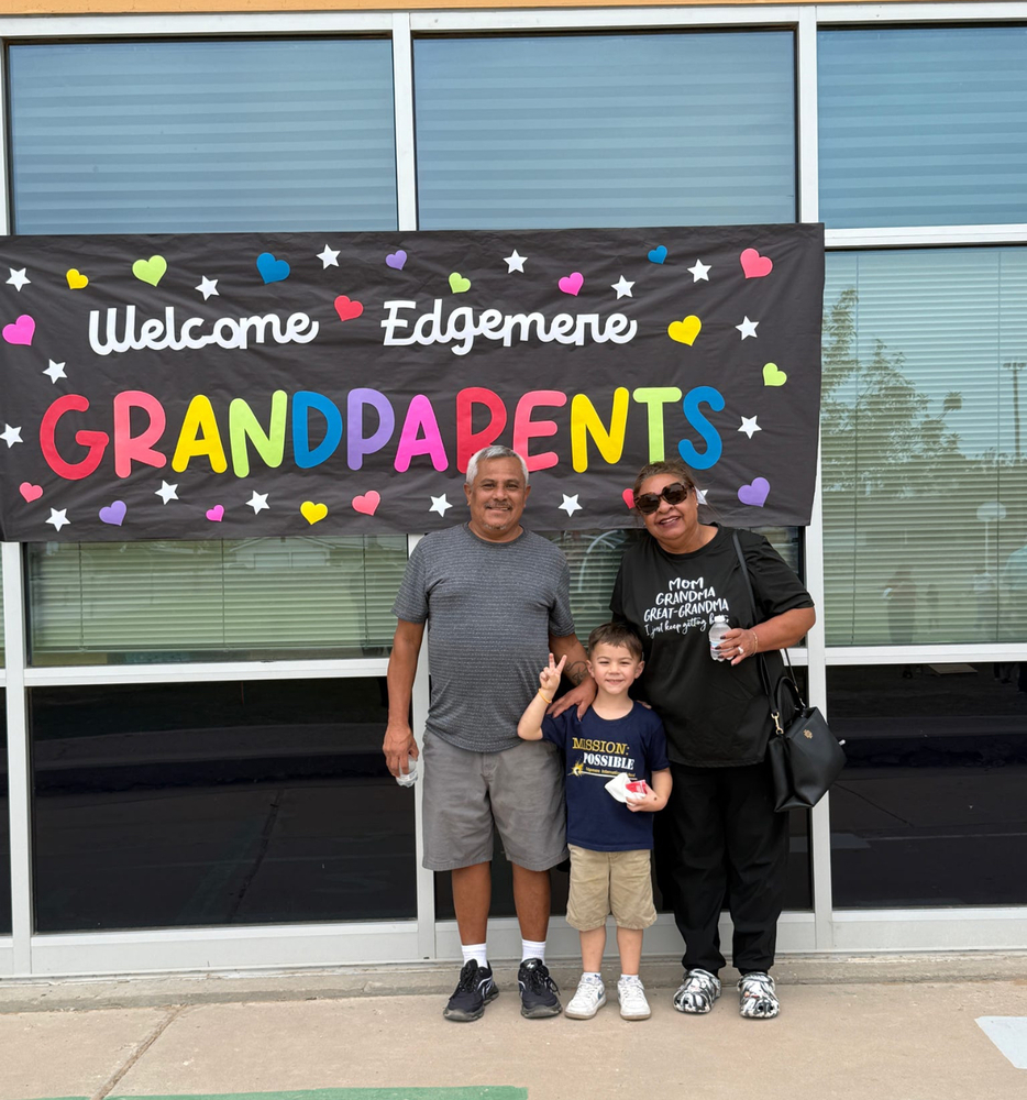 grandparents standing with student