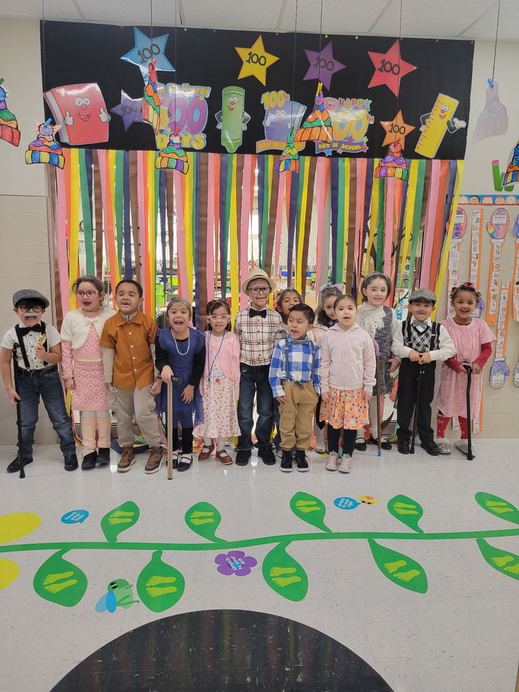 Students are posing for a picture celebrating 100 days of school by dressing up as a 100 year old student.