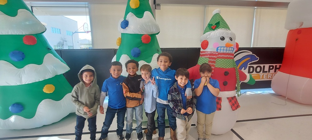 Students pose for a picture in front of some Christmas/ Holiday inflatable decorations.