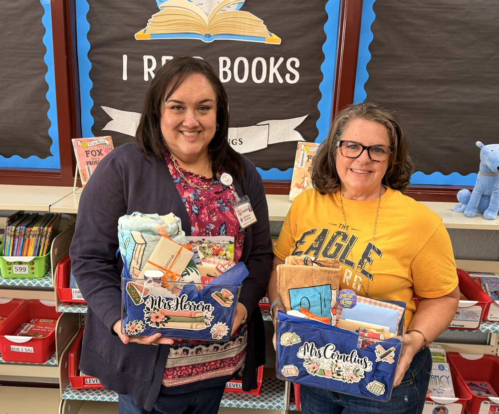 Both instructional coaches pose with the gift baskets they received.