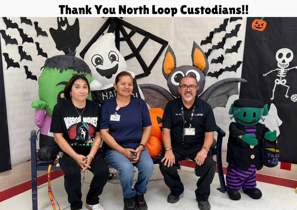 Custodians sitting in front of Halloween decorations.