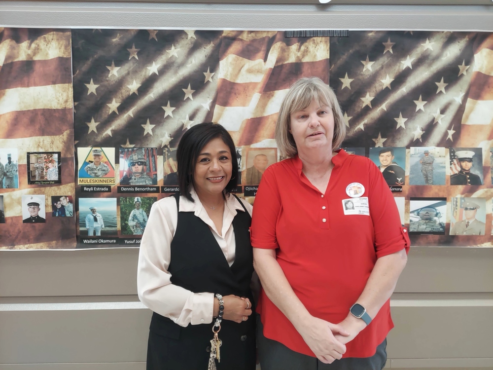 Ft. Bliss's Simone Hendricks and Dolphin Terrace Principal Lorraine Martinez pose for a picture by our Military Board of Heros.