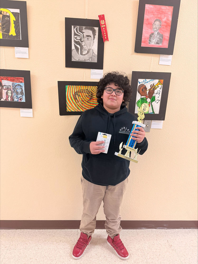 student posing with trophy for art contest