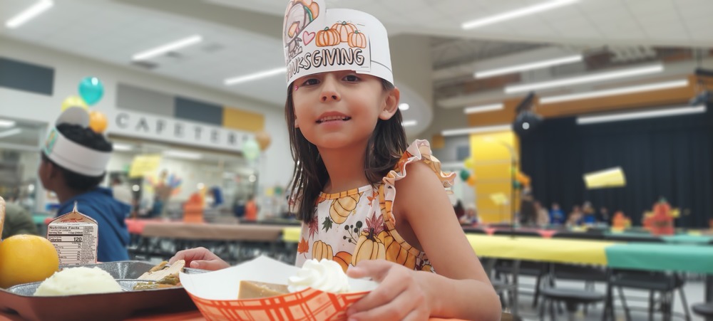 Female student is eating her Thanksgiving Lunch.