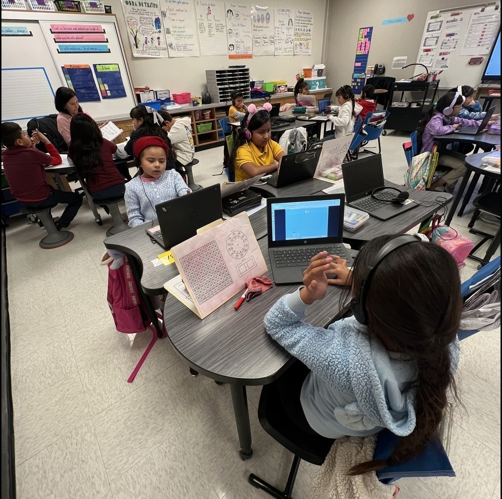 students on computer while some work in small groups