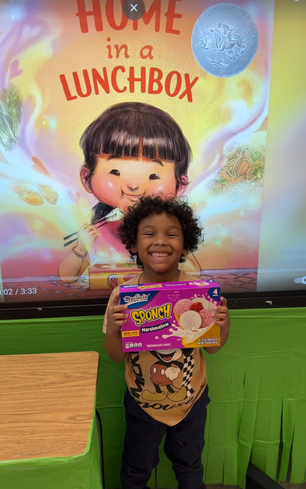 student holding a box of sponch cookies