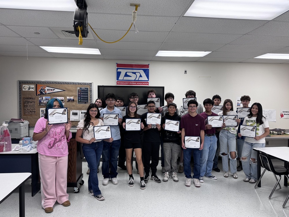 17 Students in Ms. Garcia's class pose each holding their certificates in their classroom
