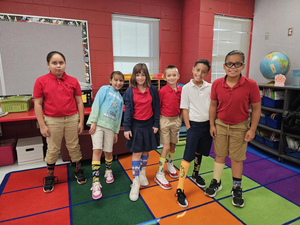 4th grade show off their crazy socks to celebrate Wilson the Wildcat's birthday