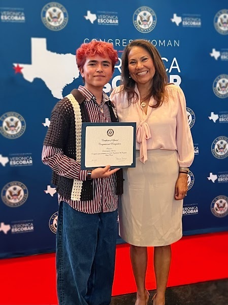 Student, Giovanny Ortiz, stands alongside Congresswoman Veronica Escobar holding a certificate.