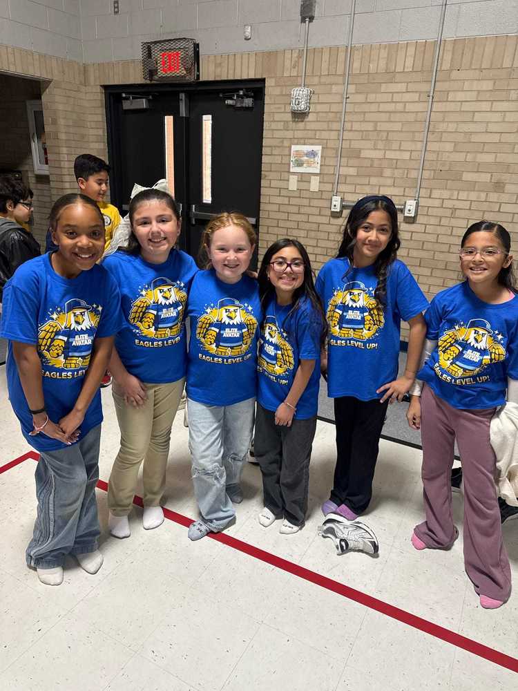 Group of students posing for a photo with smiles on their face and they spor their Achievement Unlocked Tshirt