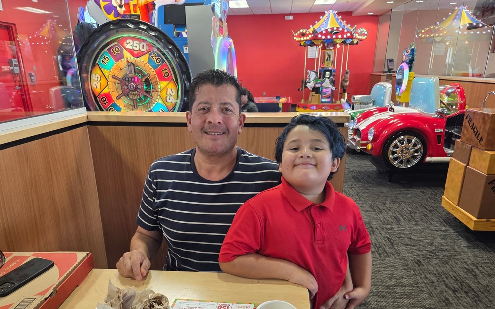 Dad and son at Peter Piper Pizza in front of the game section