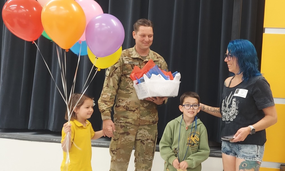Male soldier returns home to surprise his kids in shcool.