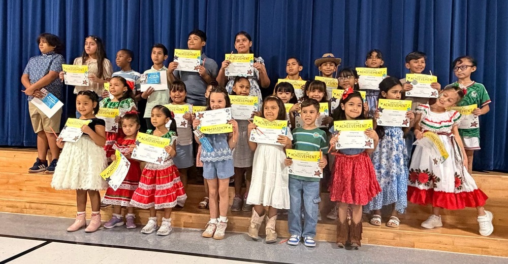 Students pose for a group picture showing off their certificates