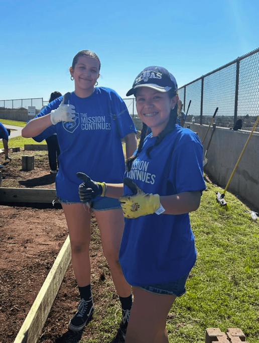 students in the ywla garden with tools and gardening
