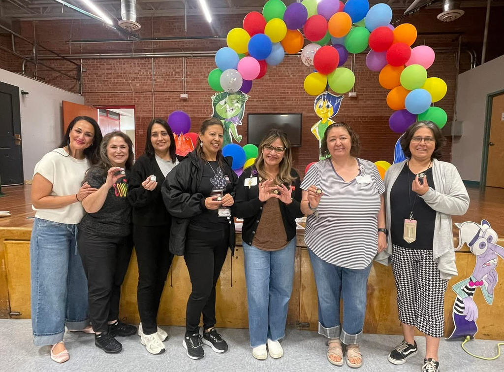Teachers showing their pins for years of service