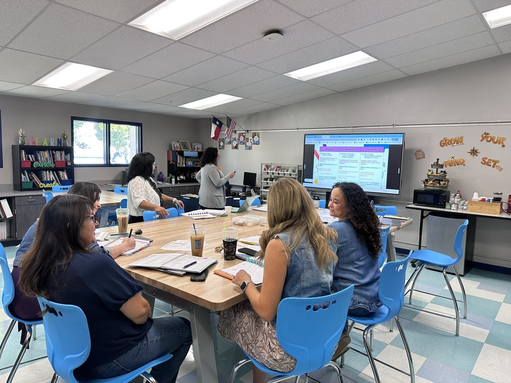 Photo of EKIS teachers getting information and preparing for the new year at a PLT meeting.