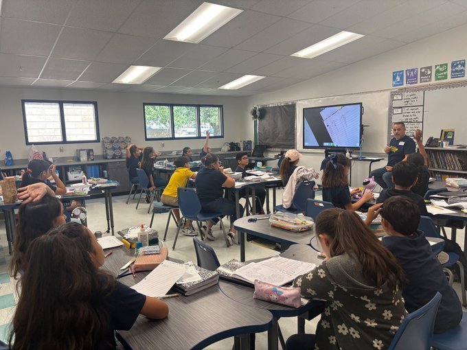 Photo of Mr. Puga with Ms. Barrios' 4th grade class giving instruction.