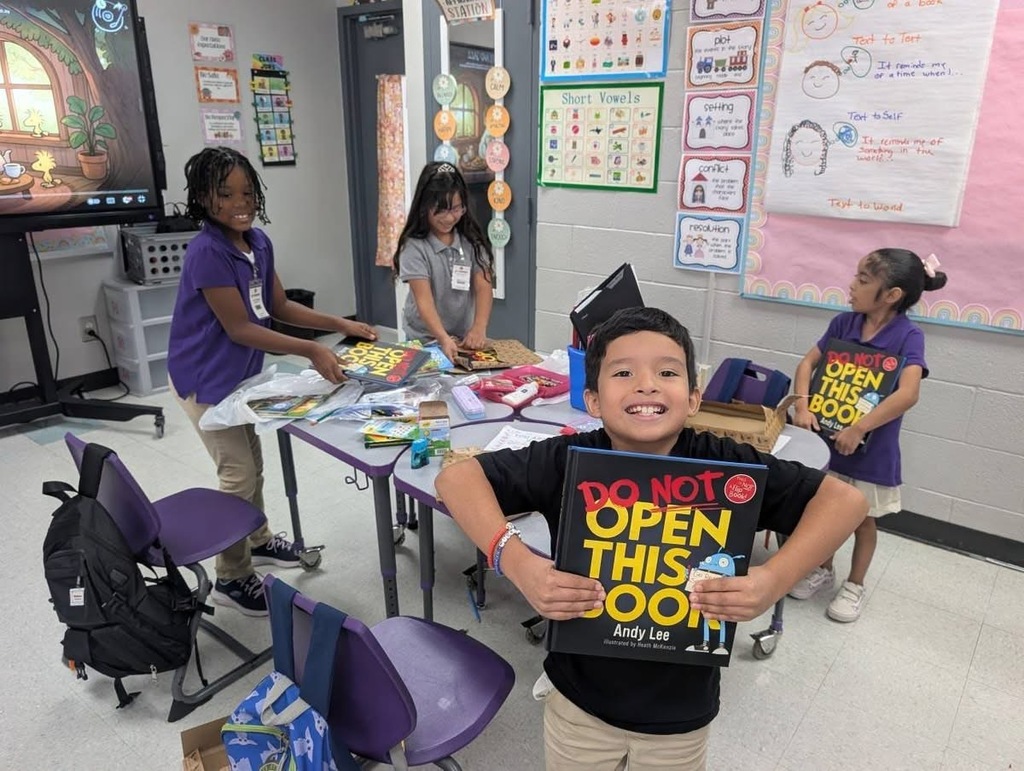 Students  holding up their new books. 
