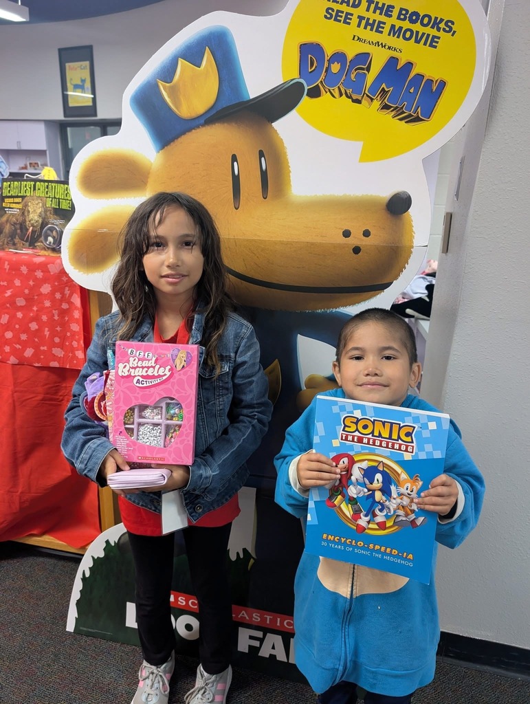 Students  holding up their books. 