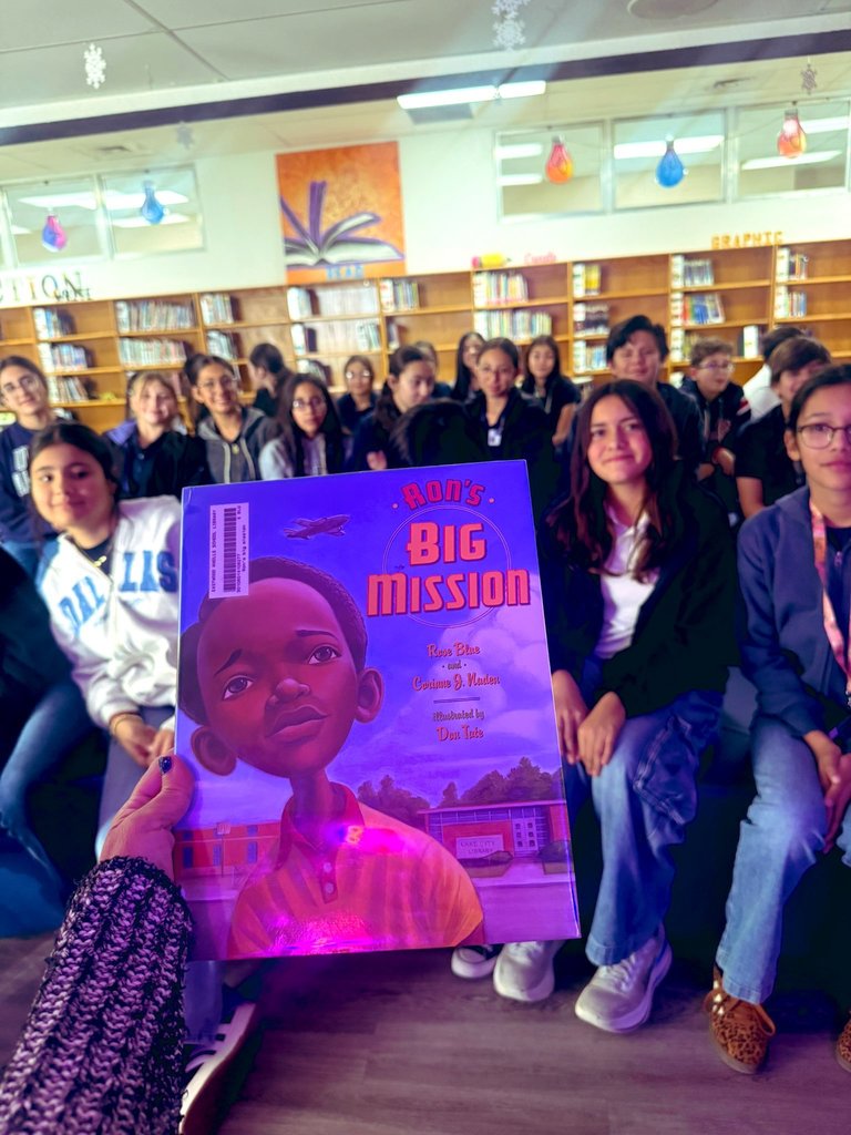 Book reading photo at the EKIS library with 7th-grade students.