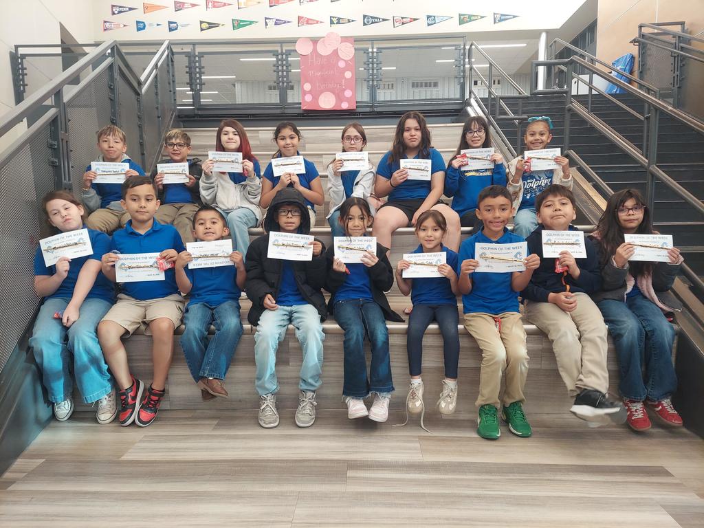Students pose for a picture holding their Dolphin of the Week certificates.