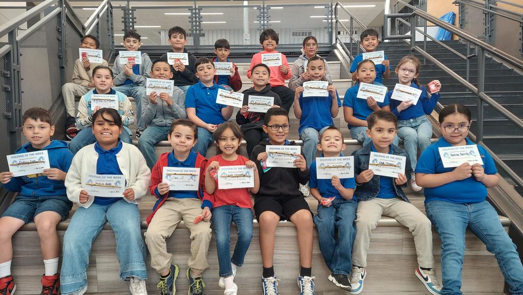 Students pose for a picture holding their Dolphin of the Week certificate.