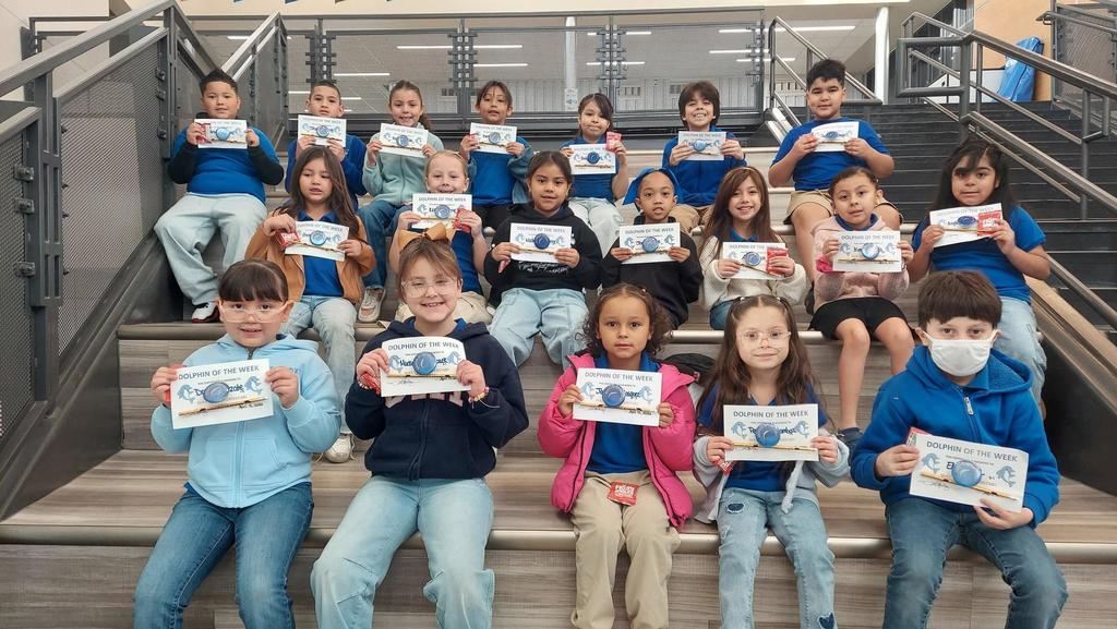 Students pose for a picture with their certificates after being chosen for Dolphin of the Week.