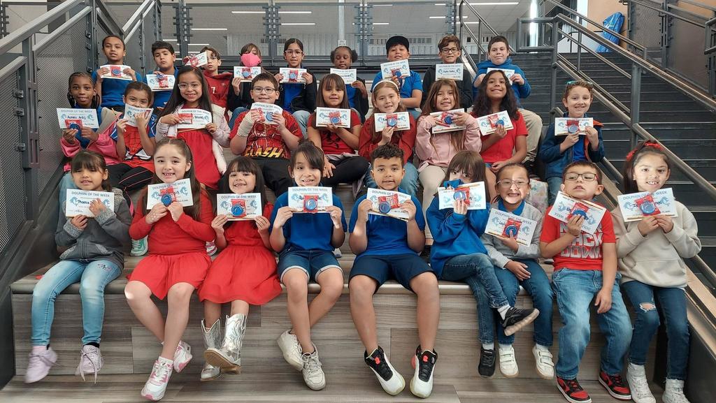 Students pose for a picture holding their Dolphin of the Week certificates.