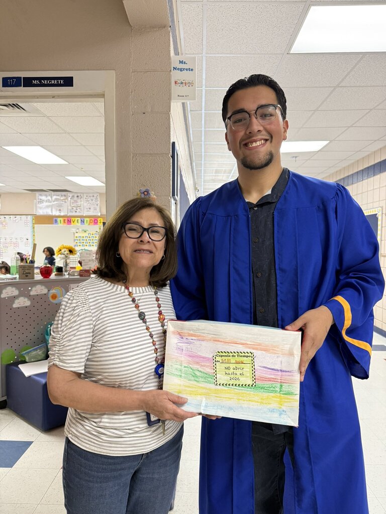 Photo of Ms. Negrete with Diego, a former kinder garden student, together holding a time capsule box from when he was her student thirteen years ago.