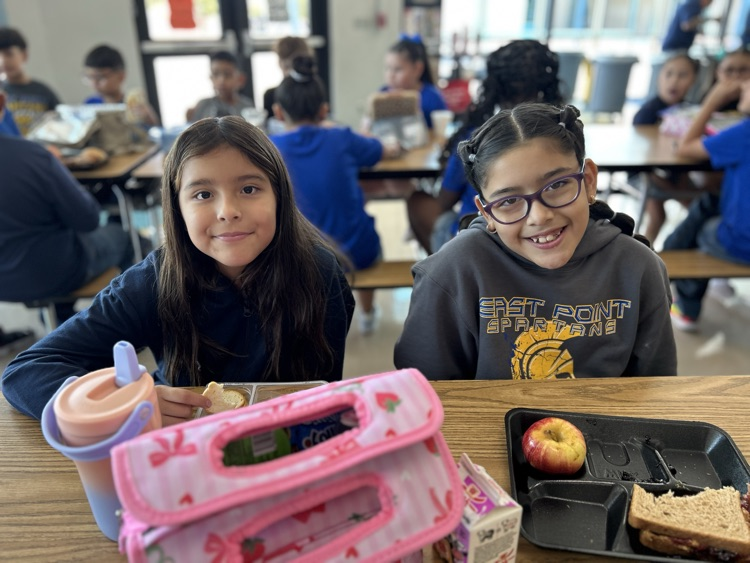 two girls posing in cafeteria 