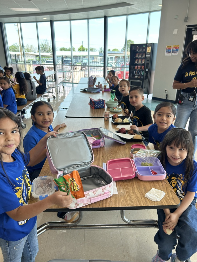 students posing eating lunch in cafeteria 